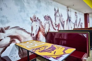 School cafeteria with horse mural behind booths to indicate school cafeteria design. 